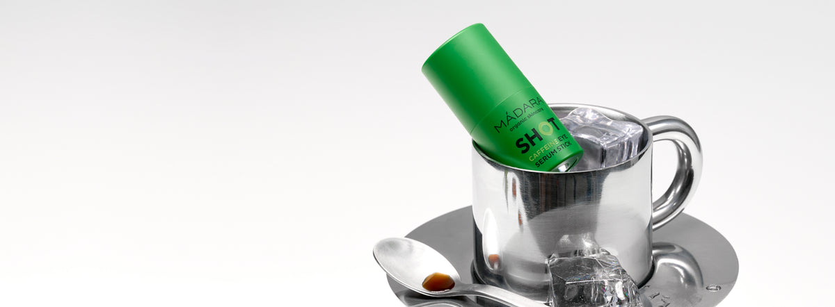 MÁDARA SHOT Caffeine Eye Serum Stick displayed in a metal cup with ice cubes