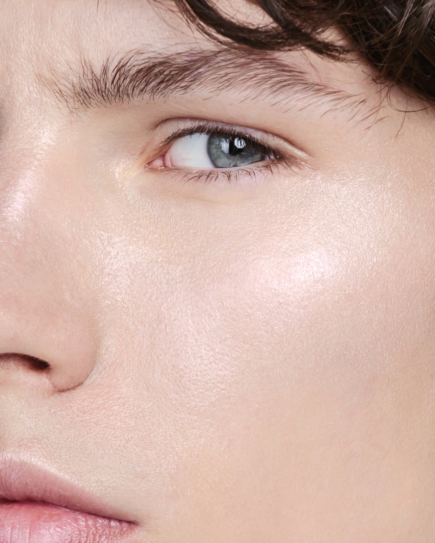 Model wearing MÁDARA Organic Skincare the concealer latte on A6101 concealer on skin; close-up portrait shows natural application results.