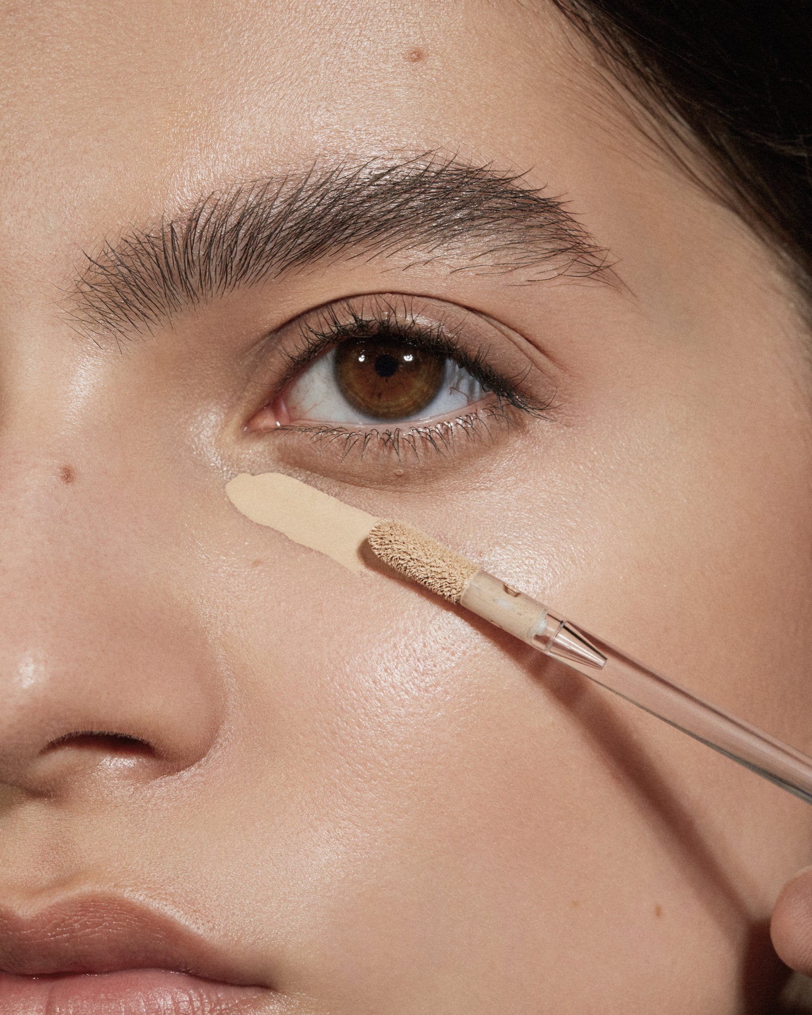 Model wearing MÁDARA Organic Skincare the concealer warm latte on A6108 concealer on skin; close-up portrait shows natural application results.