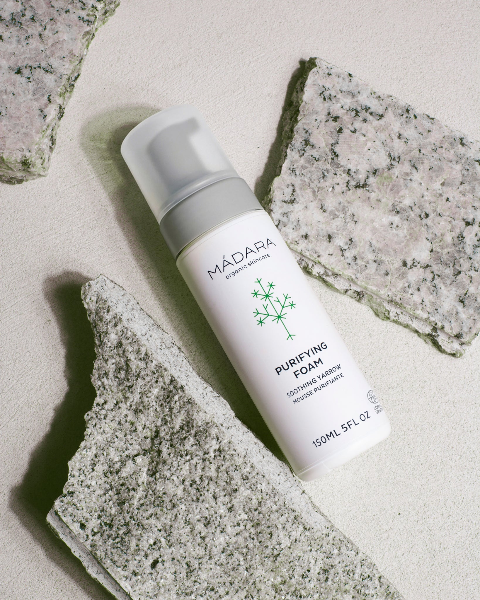 MADARA Purifying Foam bottle on a stone surface
