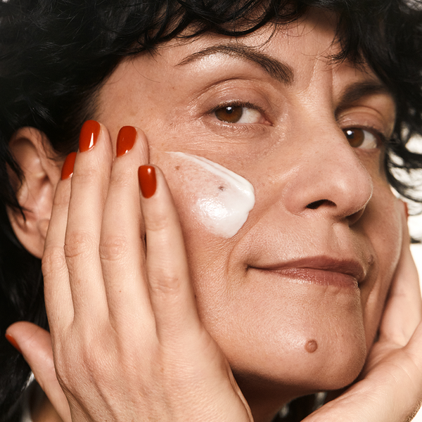 Woman applying Madara Cosmetics natural moisturizing face cream that reduces wrinkles, slows aging, and hydrates the skin.