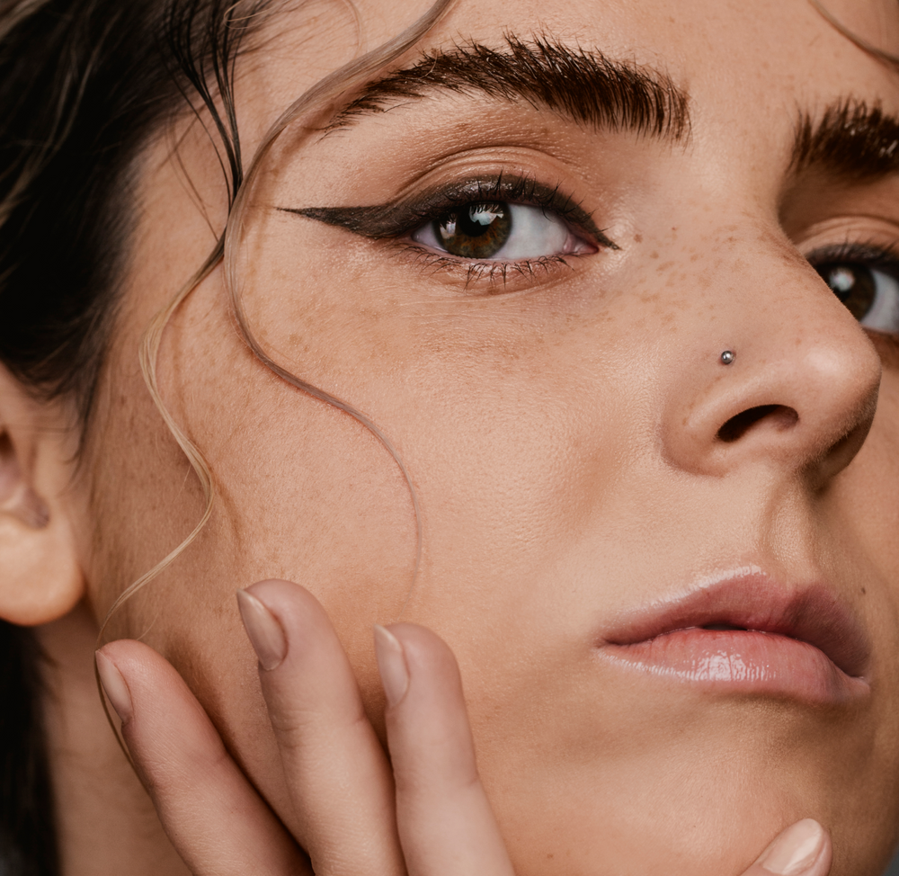 close-up of womans facial skin and her eyebrows covered with Madara Grow Fix Tinted lash booster